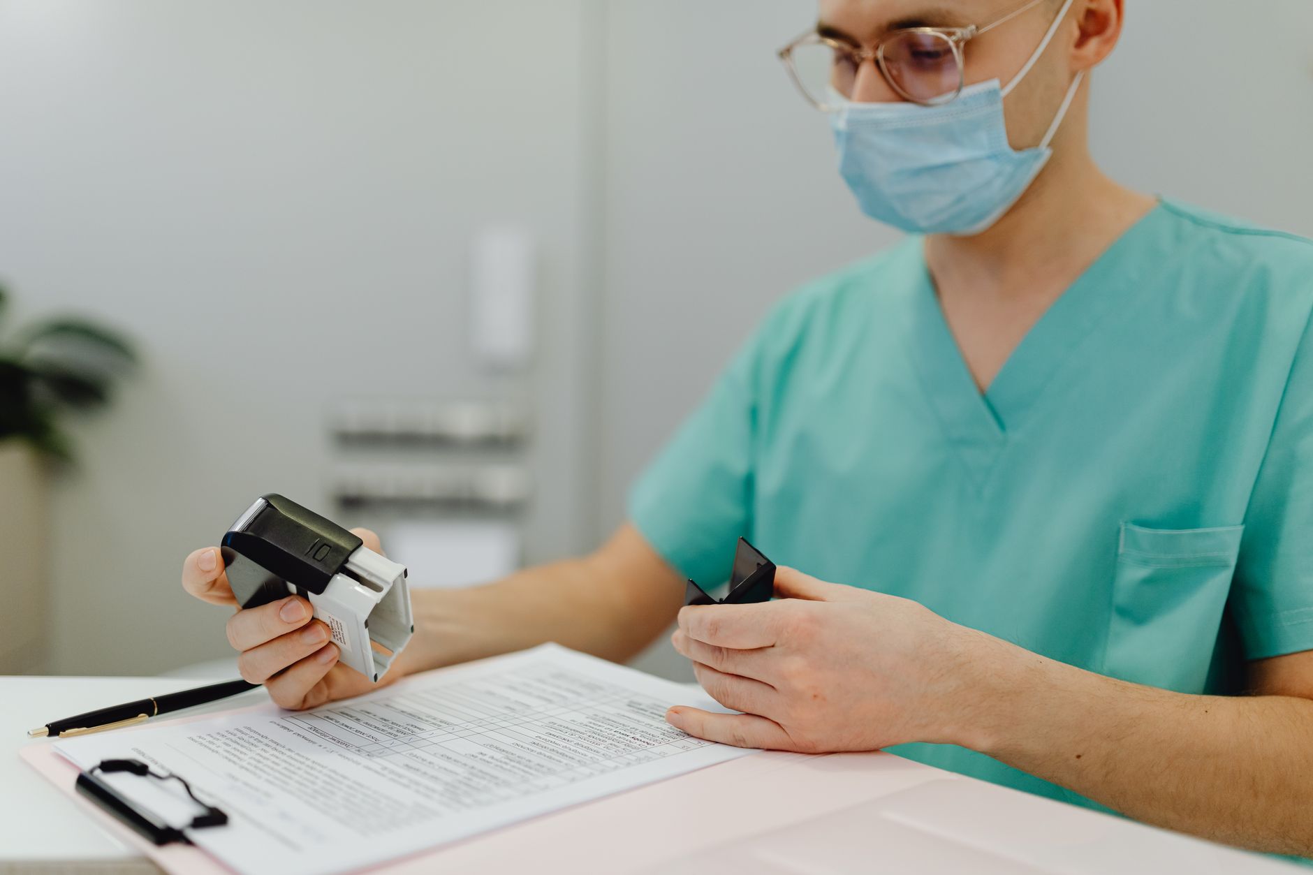 Physician completing medical credentialing and enrollment paperwork at a new practice front desk